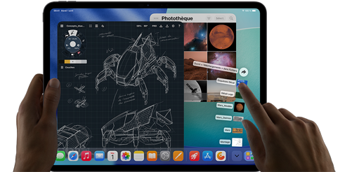 iPad Pro, noir sidéral, main gauche tenant l’appareil, main droite montrant un geste de pointage pour manipuler plusieurs fenêtres d’apps ouvertes, une app de dessin avec des croquis de designs mécaniques, une photothèque montrant des images de planètes et de l’espace, des fichiers en éventail dans le dossier Téléchargements